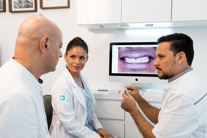 The patient and the dentists discuss a full mouth reconstruction treatment in Mexico.