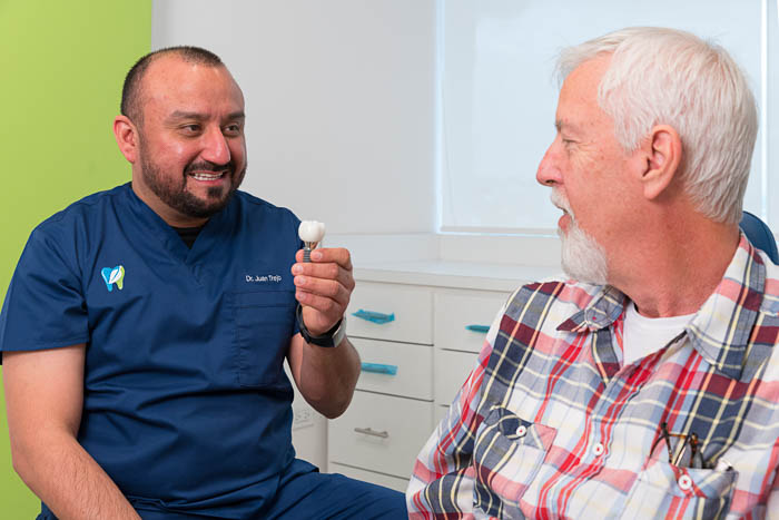 The full smile make over doctor in mexico is smiling with the patient.