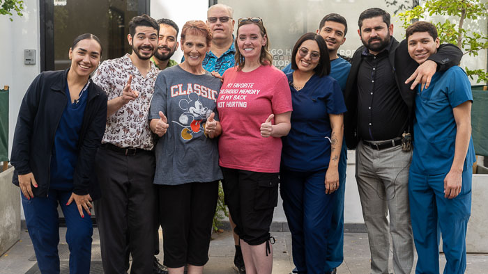 Implant Supported Bridge doctors with happy patient smiling after treatment.