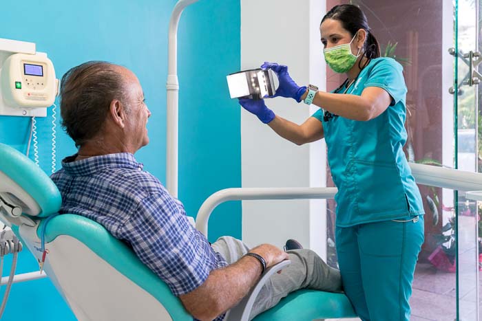 The bone graft doctor is taking a photo to the patient after the treatment.